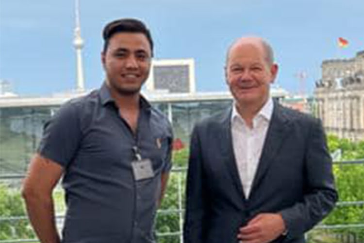 Former refugee and now manager Morteza with German Chancellor Olaf Scholz